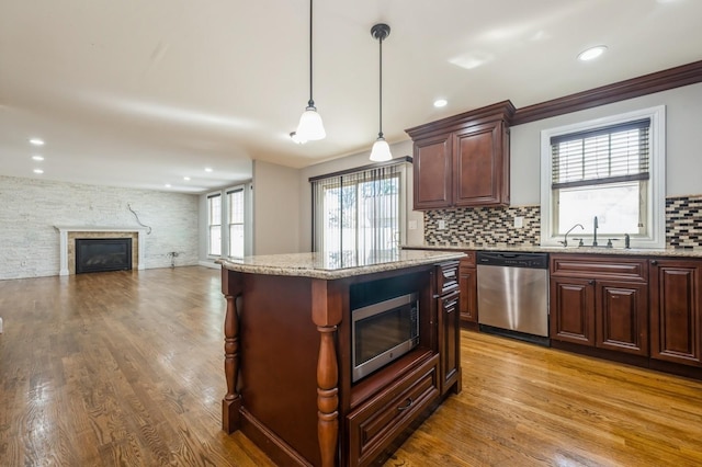 413 Robyn Pl, East Meadow, NY 11554 - kitchen featuring appliances with stainless steel finishes, a fireplace, backsplash, a kitchen island, and pendant lighting