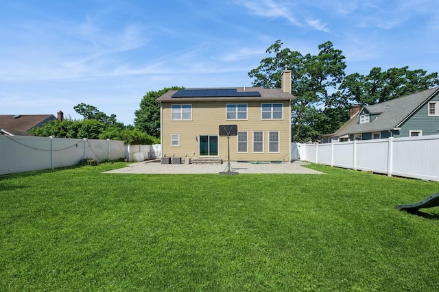 413 Robyn Pl, East Meadow, NY 11554 - back of house with a patio area, solar panels, a chimney, and a fenced backyard