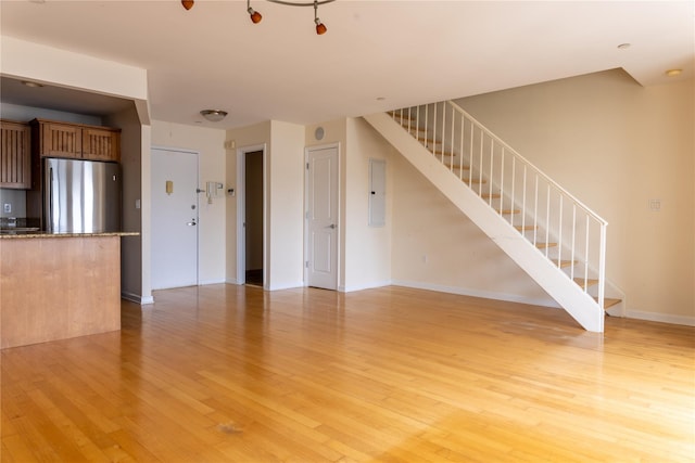 600 Clarence Ave Unit 2H, Bronx, NY 10465 - unfurnished living room with light wood finished floors, electric panel, and stairs