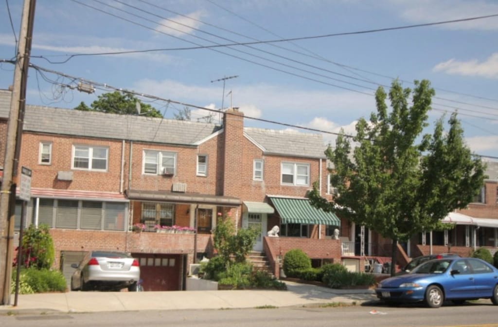 58-13 150th St, Flushing, NY 11355 - view of front facade featuring brick siding and an attached garage