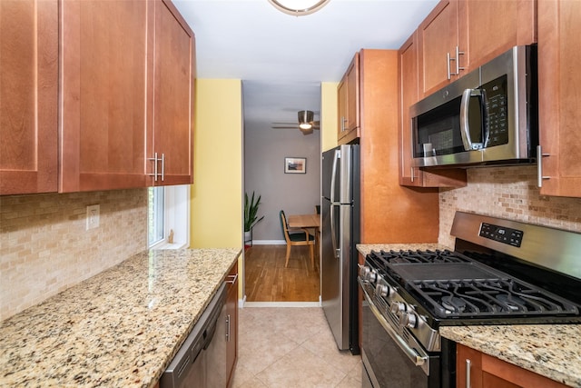 625 Gramatan Ave Unit 6L, Fleetwood, NY 10552 - kitchen featuring stainless steel appliances, backsplash, brown cabinets, and light stone counters
