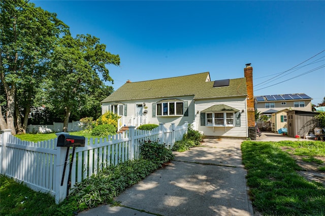 805 Arlington Rd, West Babylon, NY 11704 - view of front of home featuring a shed, concrete driveway, a chimney, and roof with shingles