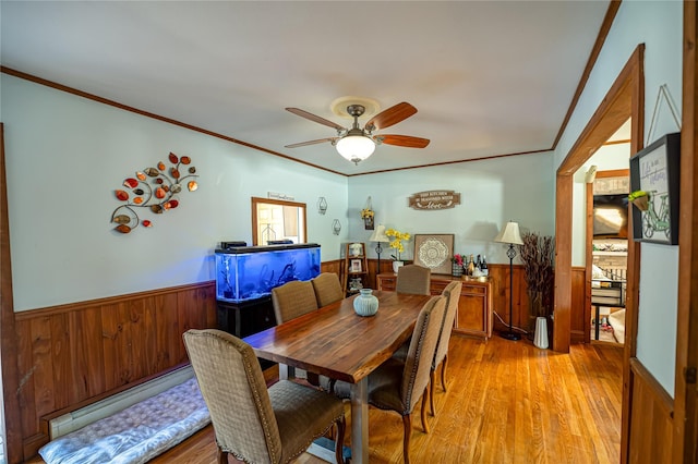 805 Arlington Rd, West Babylon, NY 11704 - dining room with wainscoting, ceiling fan, light wood finished floors, wooden walls, and ornamental molding