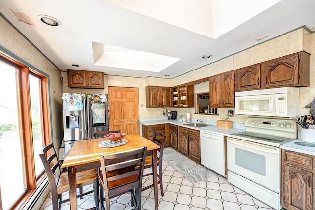 805 Arlington Rd, West Babylon, NY 11704 - kitchen with white appliances, a skylight, light countertops, and brown cabinets