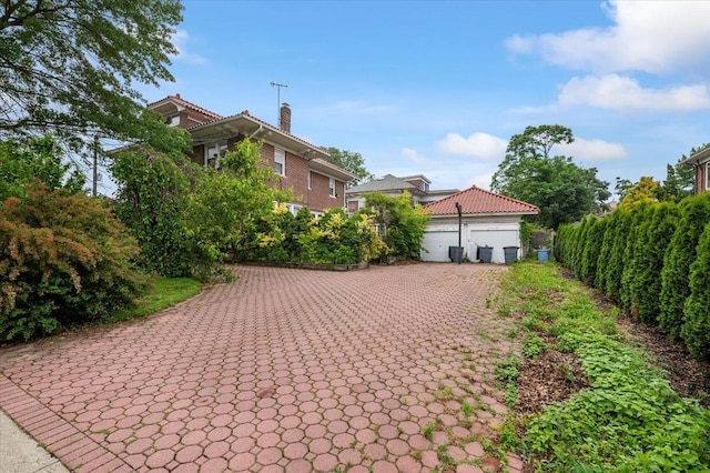 345 Broadway, Lawrence, NY 11559 - view of home's exterior with a chimney and a garage