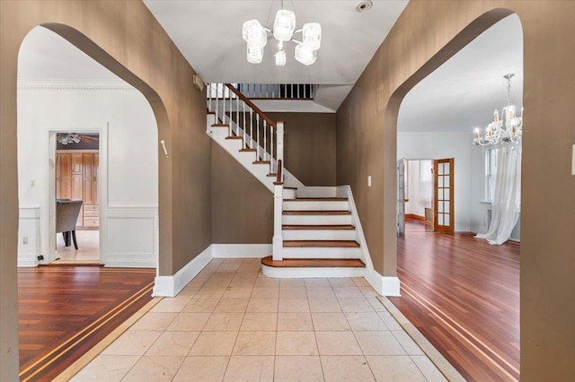 345 Broadway, Lawrence, NY 11559 - entryway with arched walkways, a chandelier, stairs, wood finished floors, and ornamental molding