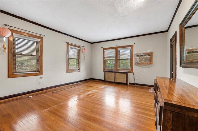 345 Broadway, Lawrence, NY 11559 - unfurnished room featuring crown molding, a wall mounted AC, light wood-style flooring, and a textured ceiling