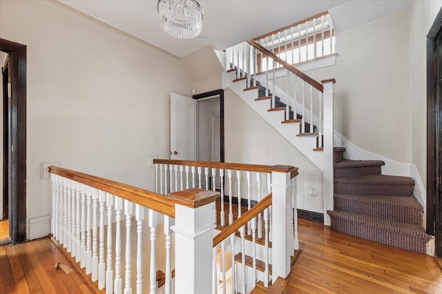 345 Broadway, Lawrence, NY 11559 - stairway featuring hardwood / wood-style floors and a chandelier