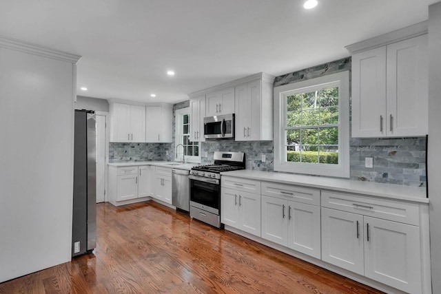 14 Sycamore St, Centereach, NY 11720 - kitchen featuring stainless steel appliances, light countertops, backsplash, white cabinetry, and dark wood finished floors