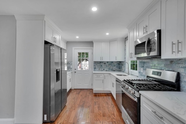 14 Sycamore St, Centereach, NY 11720 - kitchen with stainless steel appliances, light wood-style floors, white cabinetry, tasteful backsplash, and recessed lighting