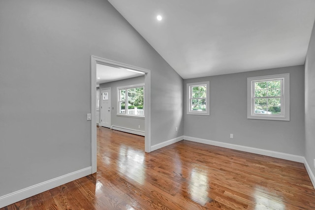 14 Sycamore St, Centereach, NY 11720 - unfurnished room with a baseboard heating unit, wood finished floors, vaulted ceiling, and recessed lighting