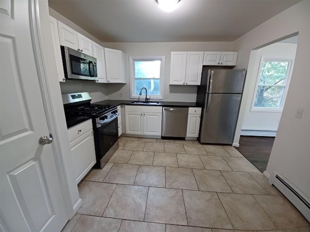14 Laddie Rd, Middletown, NY 10941 - kitchen with stainless steel appliances, a baseboard heating unit, dark countertops, and white cabinets