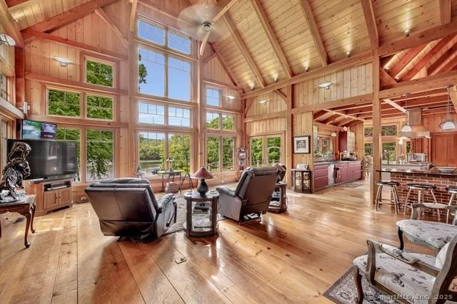 218 Kuhne Rd, Call Listing Agent, CT 06488 - living area featuring high vaulted ceiling, light wood-type flooring, a wooden ceiling with exposed beams, and wood walls