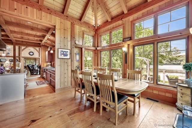 218 Kuhne Rd, Call Listing Agent, CT 06488 - dining room featuring high vaulted ceiling, light wood-style flooring, a wooden ceiling with exposed beams, plenty of natural light, and wood walls