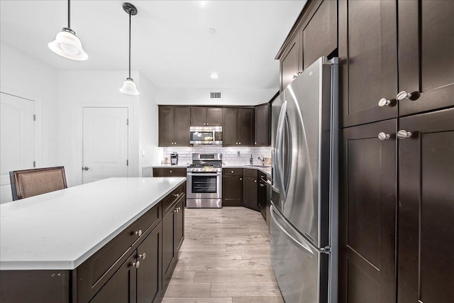 105 Captain S Way, Copiague, NY 11726 - kitchen featuring appliances with stainless steel finishes, light wood-type flooring, dark brown cabinetry, backsplash, and light countertops