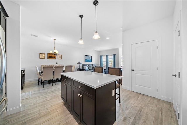 105 Captain S Way, Copiague, NY 11726 - kitchen with light wood-style floors, recessed lighting, a breakfast bar, a chandelier, and hanging light fixtures
