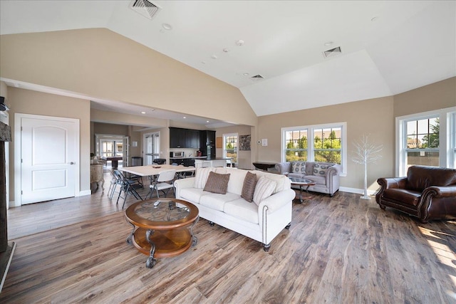 105 Captain S Way, Copiague, NY 11726 - living area with wood finished floors, healthy amount of natural light, and high vaulted ceiling