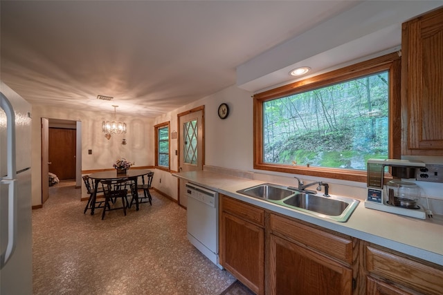 442 Main St, Grahamsville, NY 12740 - kitchen with white dishwasher, a chandelier, light countertops, brown cabinetry, and pendant lighting