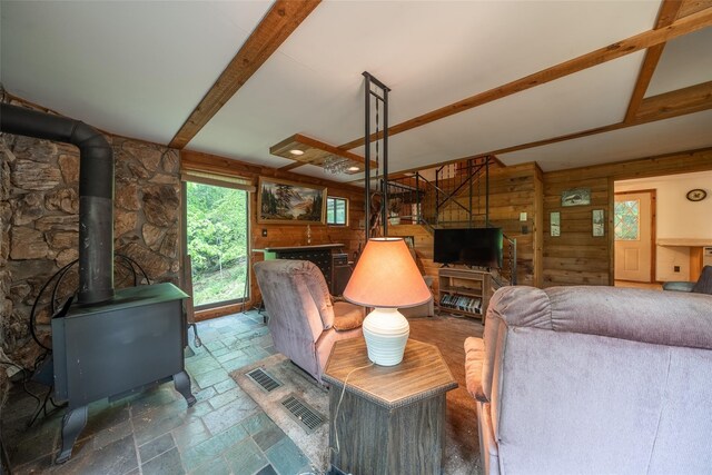 442 Main St, Grahamsville, NY 12740 - living area featuring stone tile floors, a wood stove, healthy amount of natural light, wooden walls, and beamed ceiling