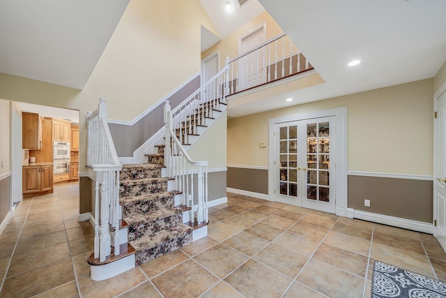 23 Antona Blvd, Centereach, NY 11720 - staircase with french doors, a baseboard heating unit, a towering ceiling, recessed lighting, and tile patterned flooring