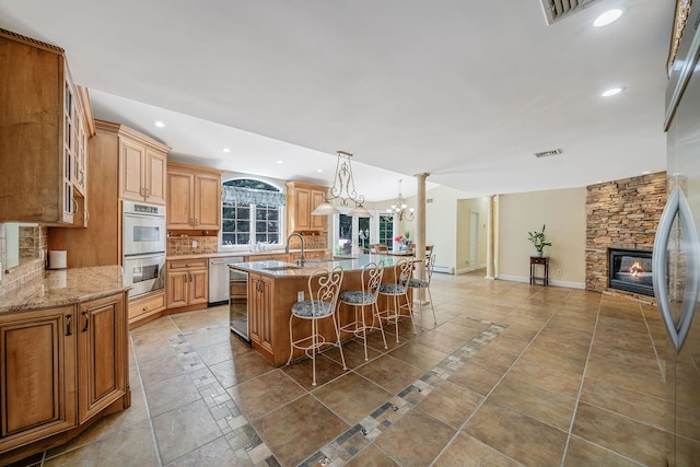 23 Antona Blvd, Centereach, NY 11720 - kitchen featuring stainless steel appliances, backsplash, a breakfast bar area, recessed lighting, and a stone fireplace