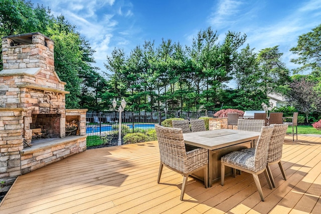23 Antona Blvd, Centereach, NY 11720 - wooden terrace featuring an outdoor stone fireplace, outdoor dining space, and view of wooded area