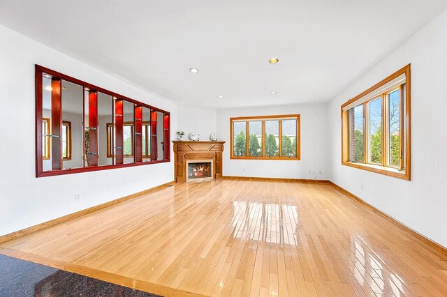 64-16 211th St, Bayside, NY 11364 - unfurnished living room featuring a warm lit fireplace, wood finished floors, and recessed lighting