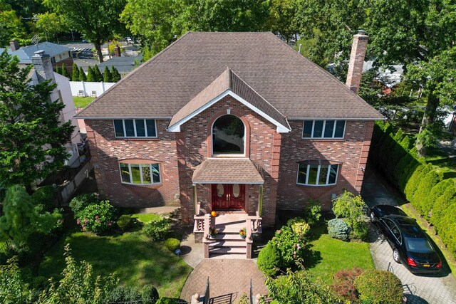64-16 211th St, Bayside, NY 11364 - traditional-style house with a chimney, brick siding, and roof with shingles