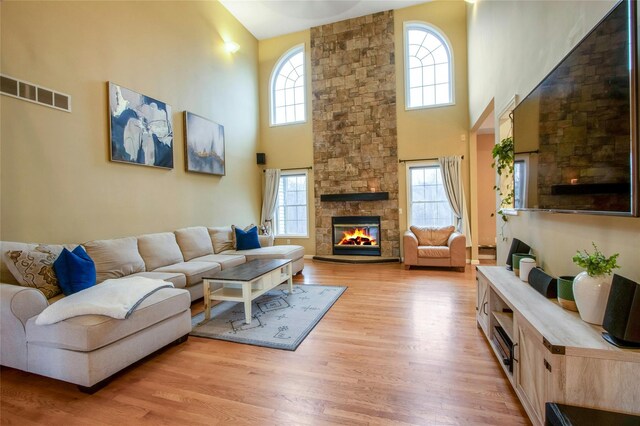 32 Gellatly Dr, Wappingers Falls, NY 12590 - living room featuring a towering ceiling, light wood-style flooring, and a fireplace
