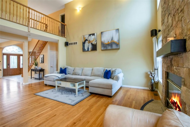 32 Gellatly Dr, Wappingers Falls, NY 12590 - living area with a high ceiling, wood finished floors, a stone fireplace, and stairway