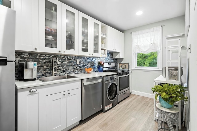 1 Avon Cir Unit D, Rye Brook, NY 10573 - kitchen featuring stainless steel appliances, washer / clothes dryer, decorative backsplash, white cabinets, and light countertops