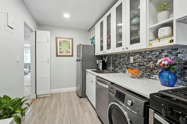 1 Avon Cir Unit D, Rye Brook, NY 10573 - kitchen with stainless steel appliances, washer / clothes dryer, decorative backsplash, light countertops, and light wood finished floors