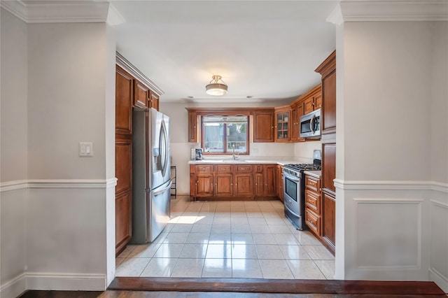 189 Stanton Blvd, Uniondale, NY 11553 - kitchen with stainless steel appliances, brown cabinetry, light countertops, light tile patterned flooring, and glass insert cabinets