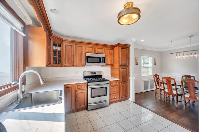 189 Stanton Blvd, Uniondale, NY 11553 - kitchen featuring appliances with stainless steel finishes, crown molding, brown cabinetry, light tile patterned floors, and glass insert cabinets
