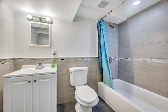189 Stanton Blvd, Uniondale, NY 11553 - full bathroom featuring tile walls, shower / tub combo with curtain, vanity, and wainscoting