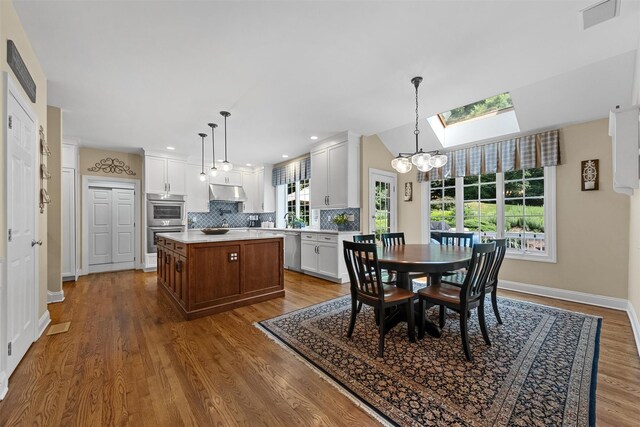 41 Carlton Dr, Mount Kisco, NY 10549 - dining space with wood finished floors, a skylight, and a chandelier