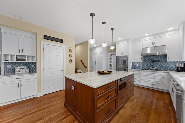 41 Carlton Dr, Mount Kisco, NY 10549 - kitchen with under cabinet range hood, stainless steel appliances, decorative backsplash, white cabinetry, and recessed lighting