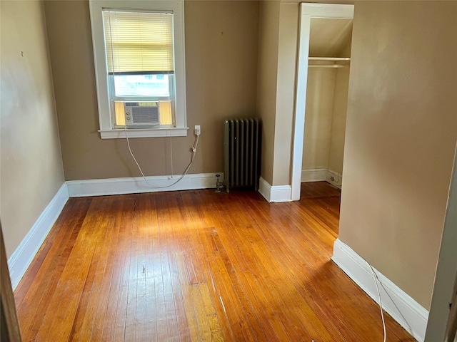 44 Waldo Ave, East Rockaway, NY 11518 - unfurnished bedroom with radiator heating unit, light wood-style floors, a closet, and cooling unit