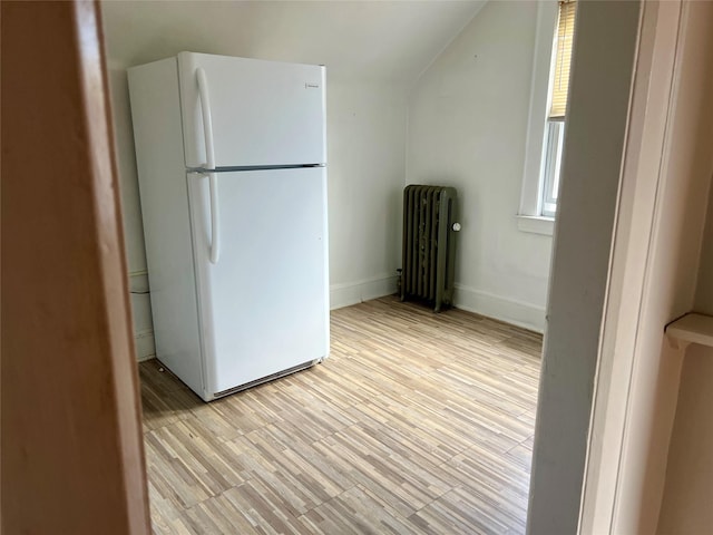 44 Waldo Ave, East Rockaway, NY 11518 - kitchen featuring freestanding refrigerator, radiator heating unit, lofted ceiling, and light wood finished floors