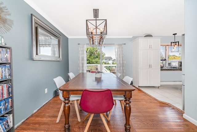 255 Rose St, Copiague, NY 11726 - dining area featuring a chandelier, crown molding, and light wood-style flooring