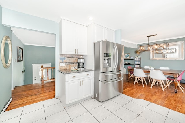 255 Rose St, Copiague, NY 11726 - kitchen featuring stainless steel fridge with ice dispenser, light tile patterned floors, crown molding, white cabinets, and tasteful backsplash