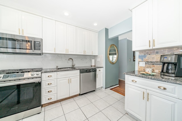 255 Rose St, Copiague, NY 11726 - kitchen with appliances with stainless steel finishes, tasteful backsplash, white cabinets, dark stone counters, and recessed lighting