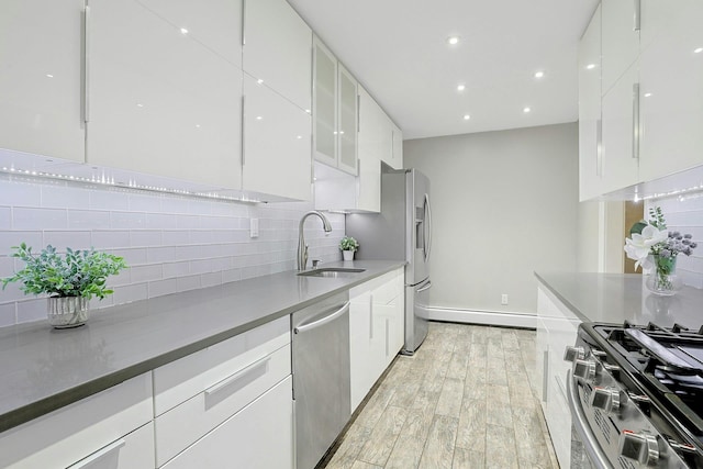 13 Darian Ct Unit 2B, Pomona, NY 10970 - kitchen featuring stainless steel appliances, baseboard heating, light wood-style flooring, white cabinets, and modern cabinets