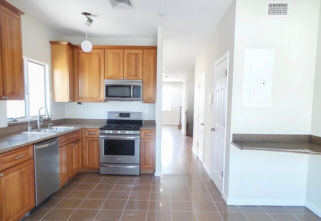 2439 E 69th St, Brooklyn, NY 11234 - kitchen featuring stainless steel appliances, electric panel, tasteful backsplash, and dark tile patterned flooring
