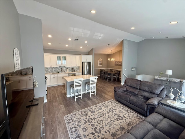 310 Narragansett Villas Dr, Lindenhurst, NY 11757 - living room featuring dark wood-type flooring, lofted ceiling, a chandelier, and recessed lighting