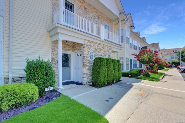 310 Narragansett Villas Dr, Lindenhurst, NY 11757 - view of exterior entry with a balcony and stone siding
