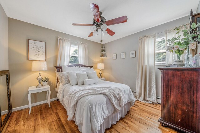 6 Pine St N, Lake Grove, NY 11755 - bedroom featuring light wood-style floors, a baseboard heating unit, and a ceiling fan