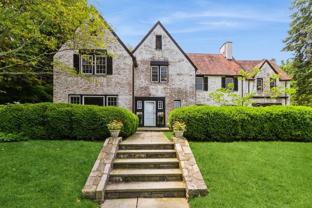 50 Overlook Dr, Chappaqua, NY 10514 - tudor home with a chimney, a front lawn, and brick siding