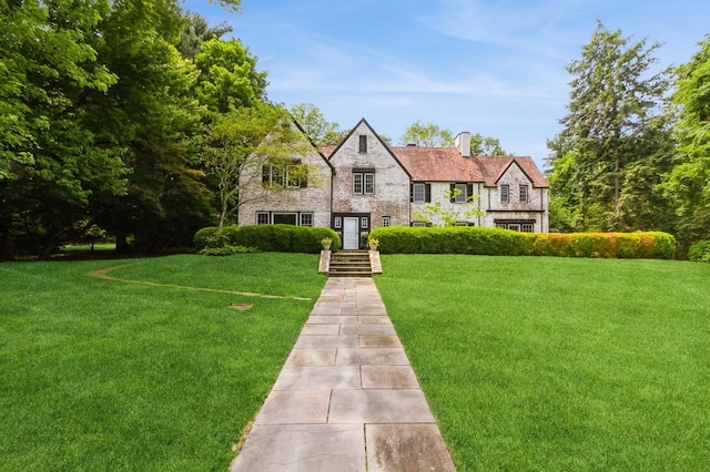 50 Overlook Dr, Chappaqua, NY 10514 - tudor home featuring a front yard, a chimney, and stone siding