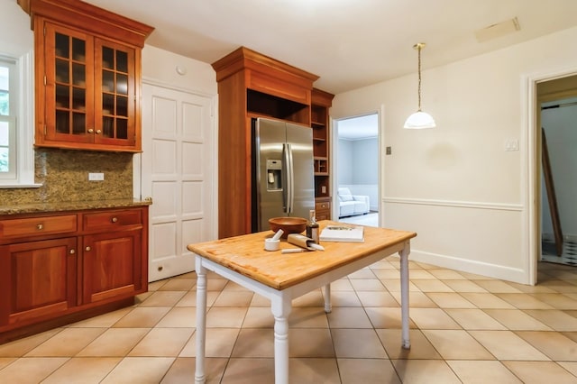 50 Overlook Dr, Chappaqua, NY 10514 - kitchen featuring stainless steel fridge, decorative backsplash, glass insert cabinets, stone counters, and hanging light fixtures